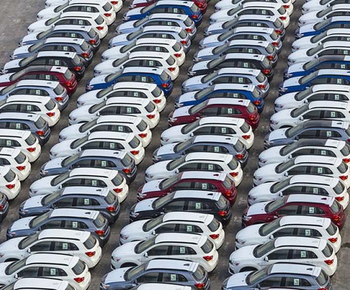 Business man checking phone near a white luxury car